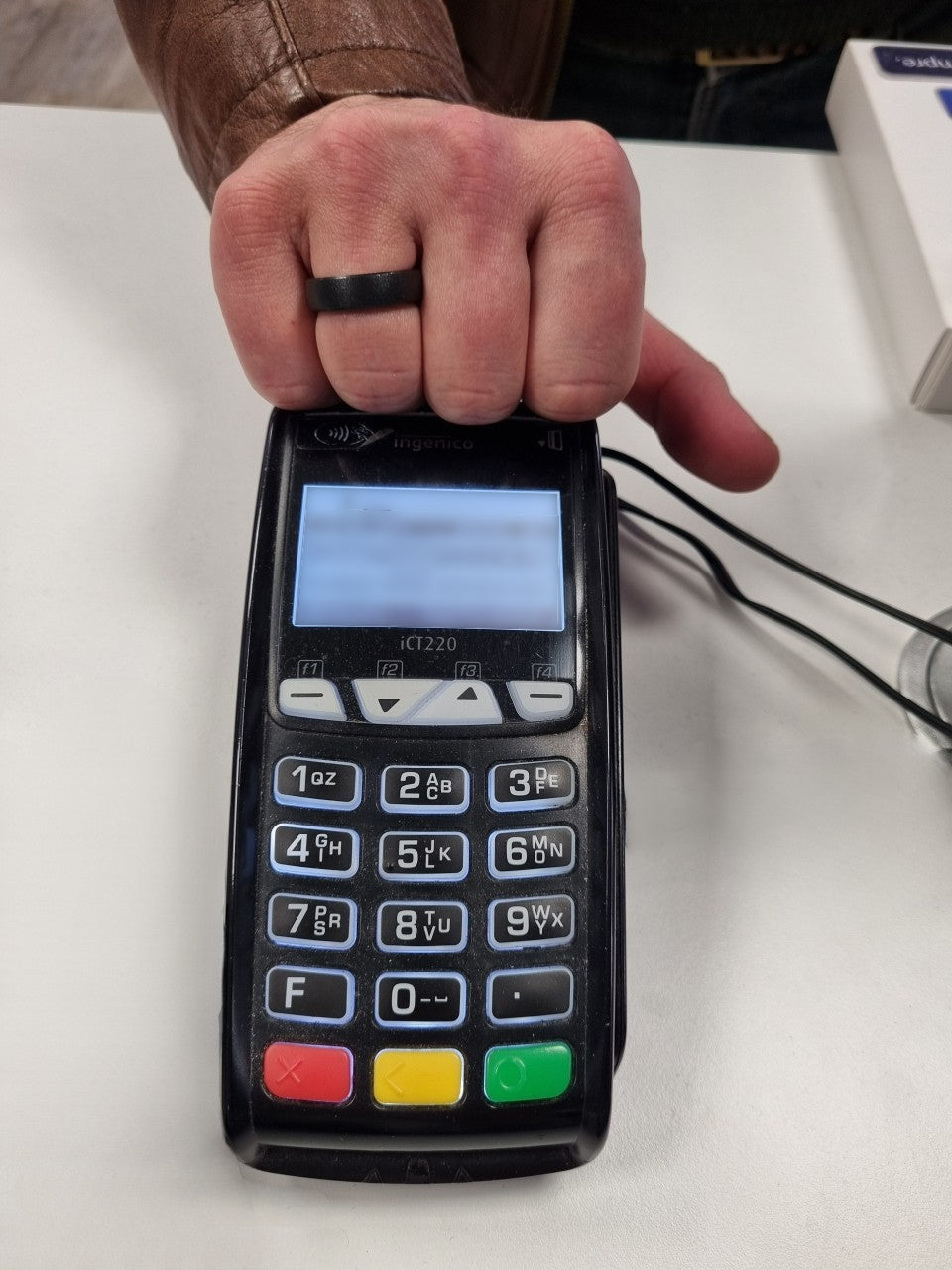 mano con anello che stà pagando, appogiando la mano sul POS